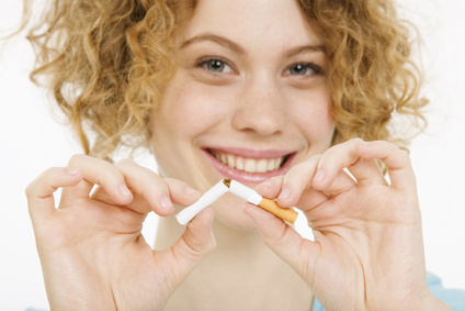 Young Woman breaking cigarette in half, smiling, portrait